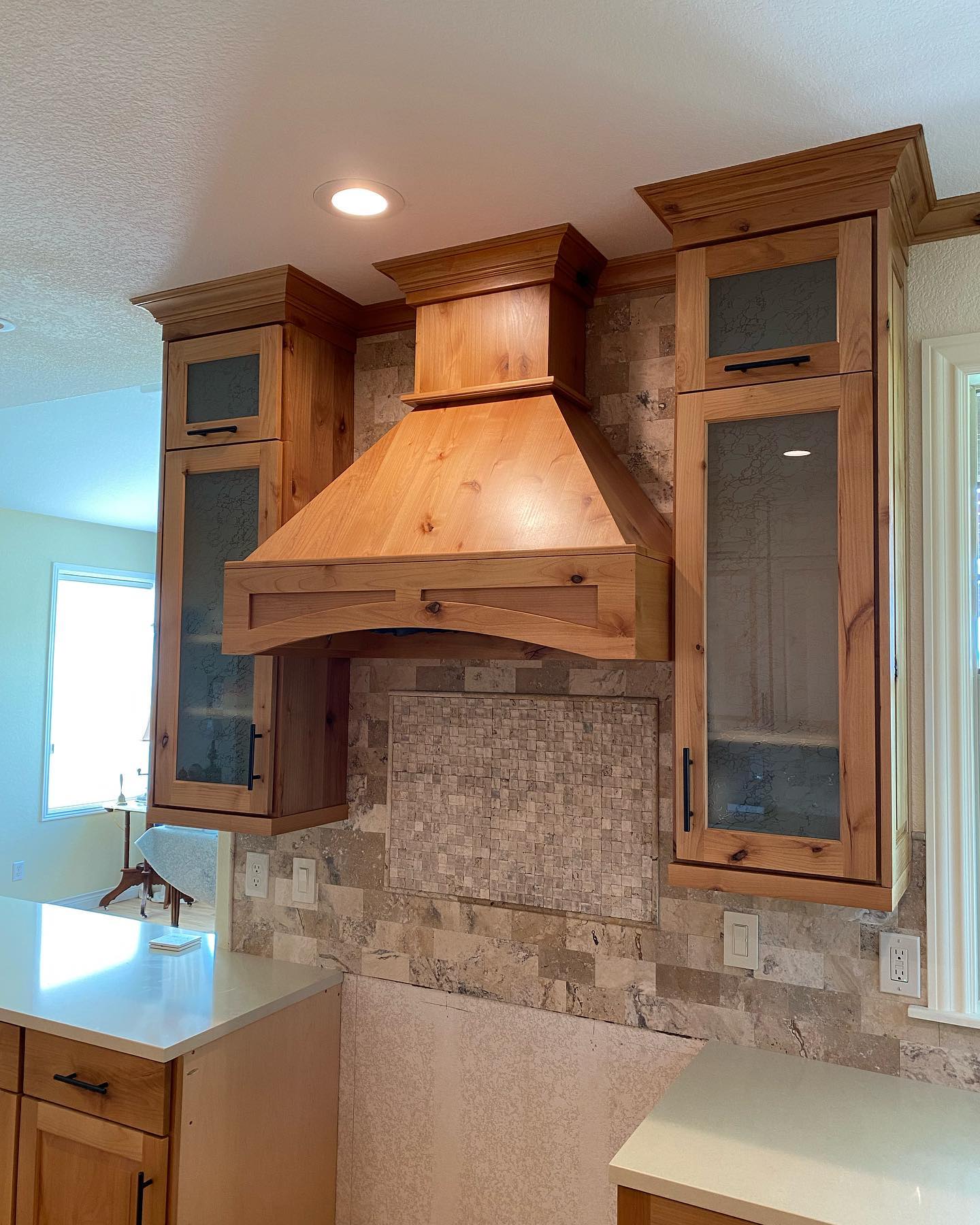 Custom range hood and travertine backsplash